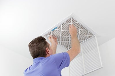 Man Changing Air Filter in Ceiling