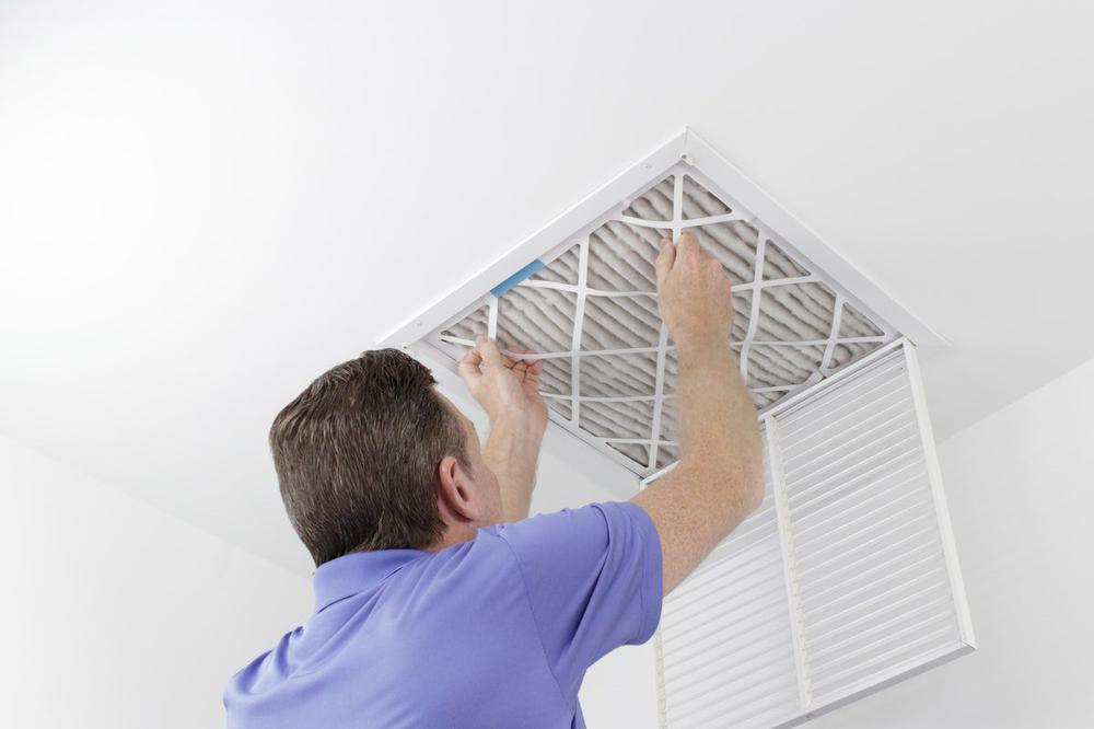 Man Changing An Air Filter in Ceiling in Home in St. Louis